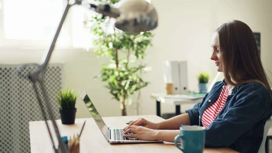 A woman working on a laptop in a modern office
