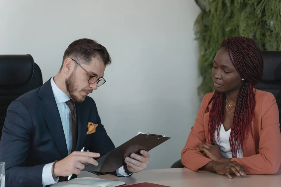 A hiring manager reviewing a printed resume with a candidate