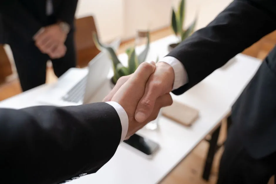 Two people shaking hands after reaching an agreement in a business meeting